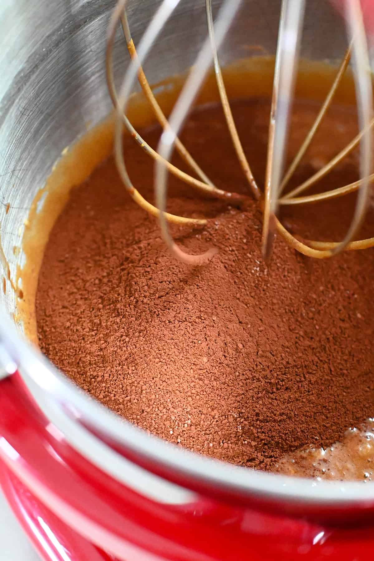 The sifted almond flour and unsweetened cocoa powder is added to the bowl of stand mixer with paleo brownie batter.