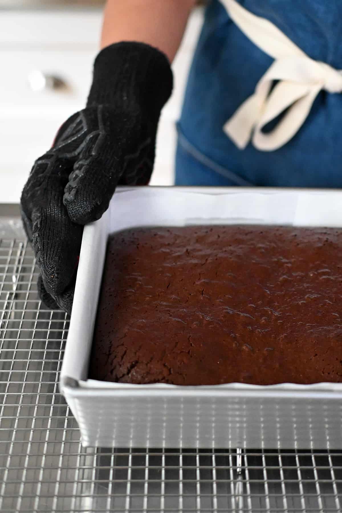 A square pan of paleo brownies is cooling on a wire rack.