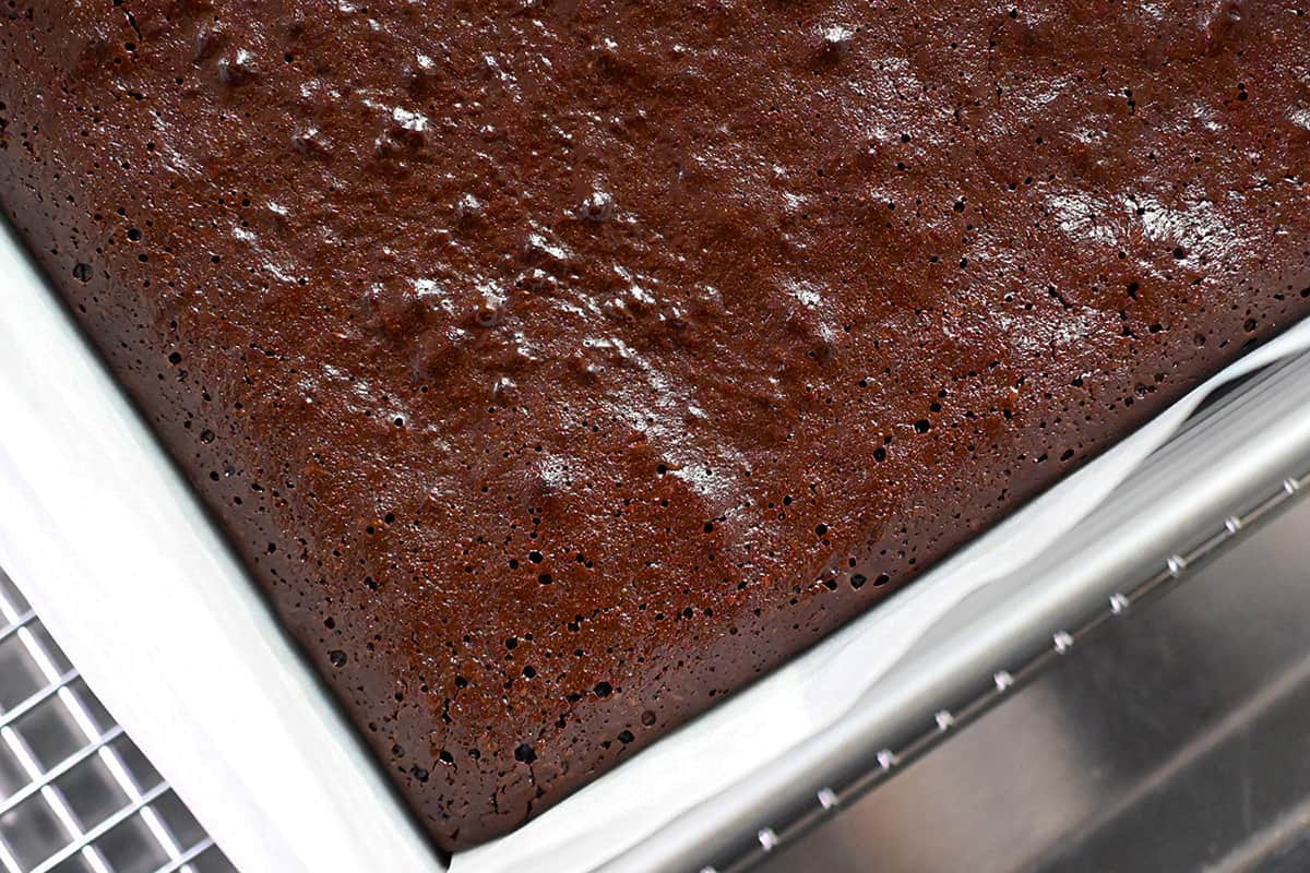 An overhead view of a corner of a pan of paleo brownies cooling on a wire rack.