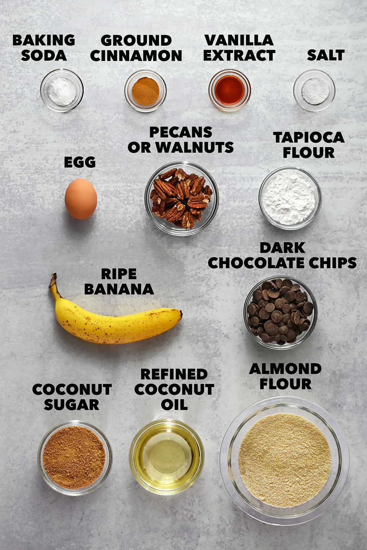 All the raw ingredients to make paleo banana cookies are measured out in small glass bowls.