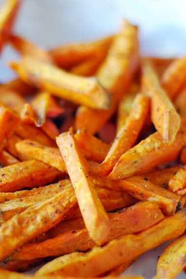 A portrait photo of oven-baked or air fryer cooked sweet potato fries.