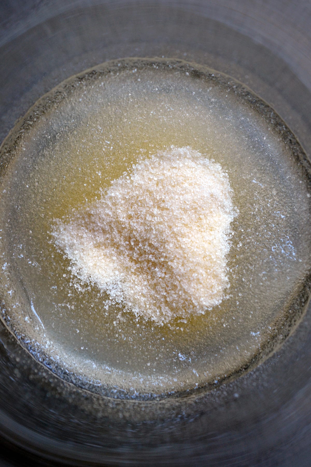 Powdered gelatin blooming in a small glass.