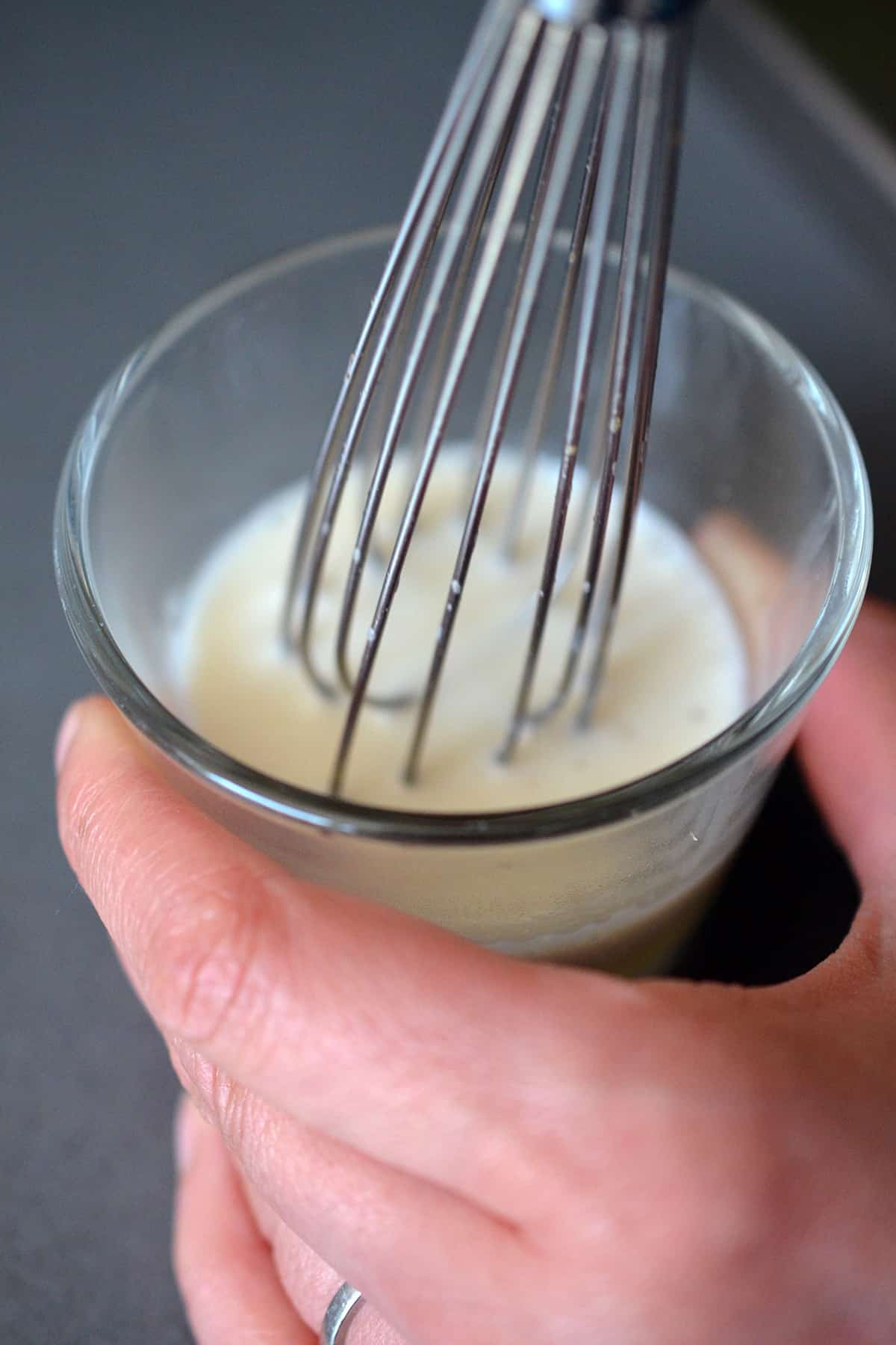 Whisking together the bloomed gelatin and the warmed almond milk.